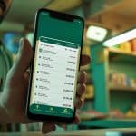 Retailer managing business finances using the Udhaar Book digital khata app on a smartphone.